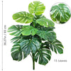 Artificial Monstera plant with silk green leaves shown in a potted form.