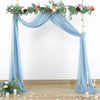 Tissu drapé de mousseline bleu clair élégant utilisé pour une arche de fond d'événement décorée de verdure et de fleurs