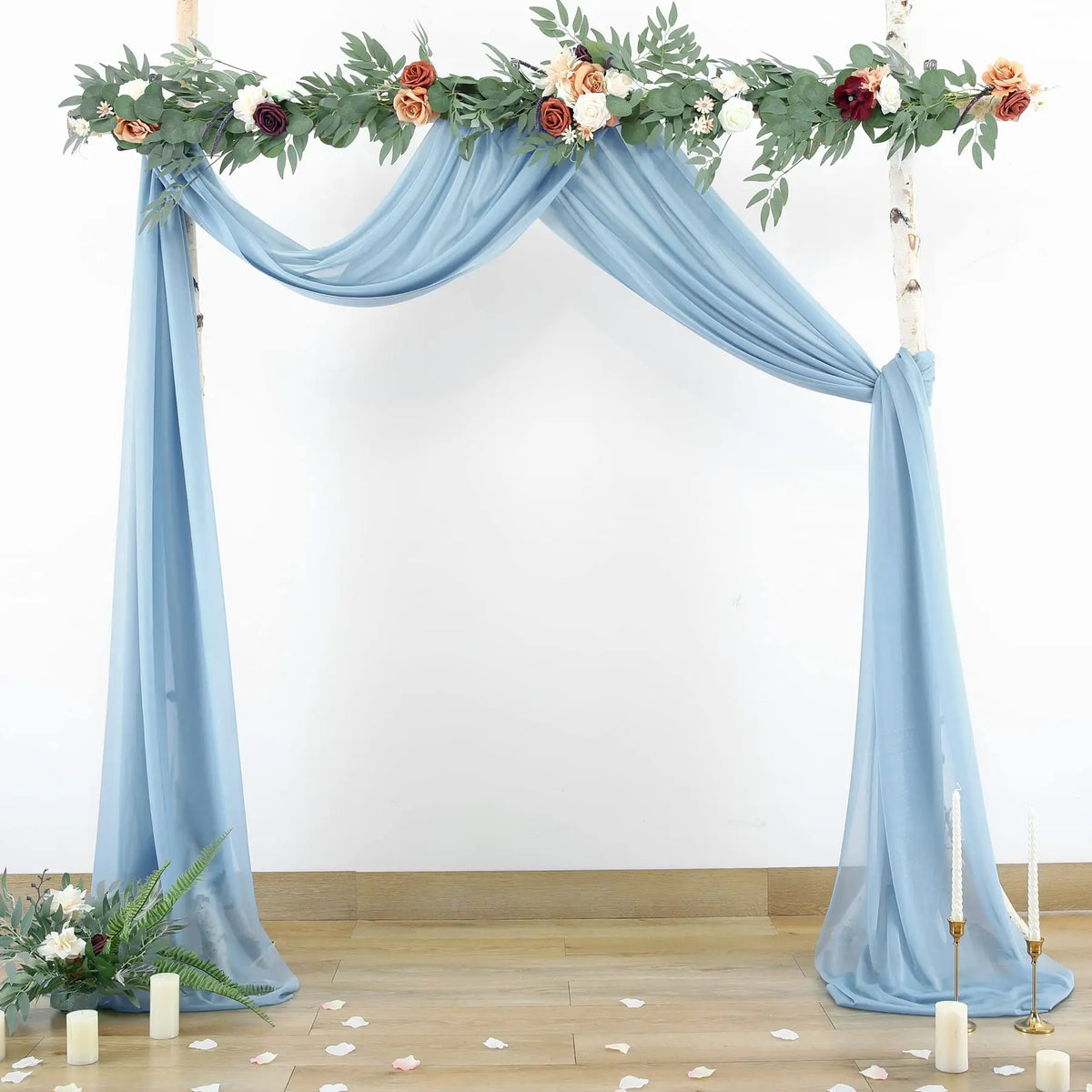 Tissu drapé de mousseline bleu clair élégant utilisé pour une arche de fond d'événement décorée de verdure et de fleurs