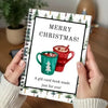 A handmade Christmas card book with a green mug design and festive greenery on the cover.