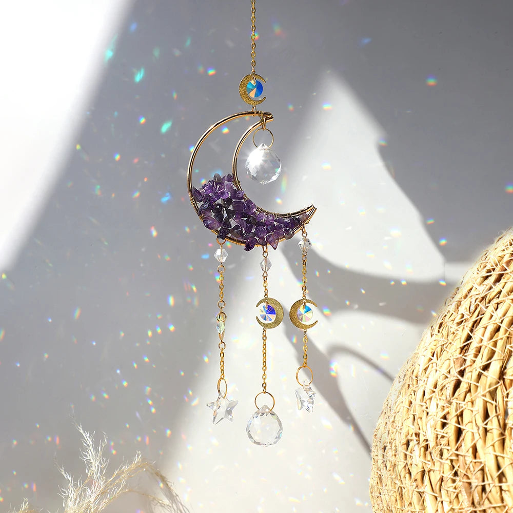 A gold dreamcatcher hangs, featuring a purple crescent moon and clear crystal beads, catching sunlight.