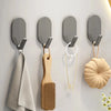 A set of five self-adhesive wall hooks featuring various shapes and materials like wood and metal.