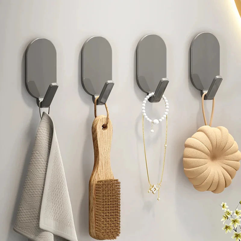 A set of five self-adhesive wall hooks featuring various shapes and materials like wood and metal.