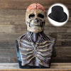 Un masque crâne réaliste avec texture de cerveau et chapeau haut de forme sur fond en bois.
