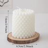 A white Nordic bubble scented soy candle is displayed on a wooden slice.