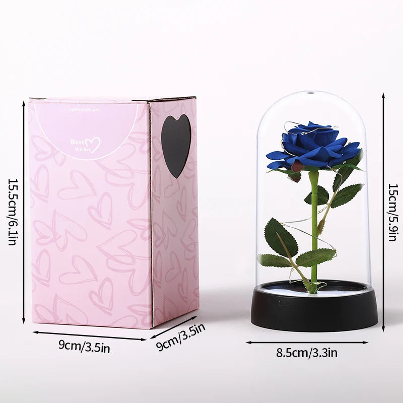A pink box and a glass dome containing an artificial blue rose.