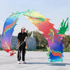 Una persona está frente a un gran arco de utilería para fitness de danza de dragones colorido.