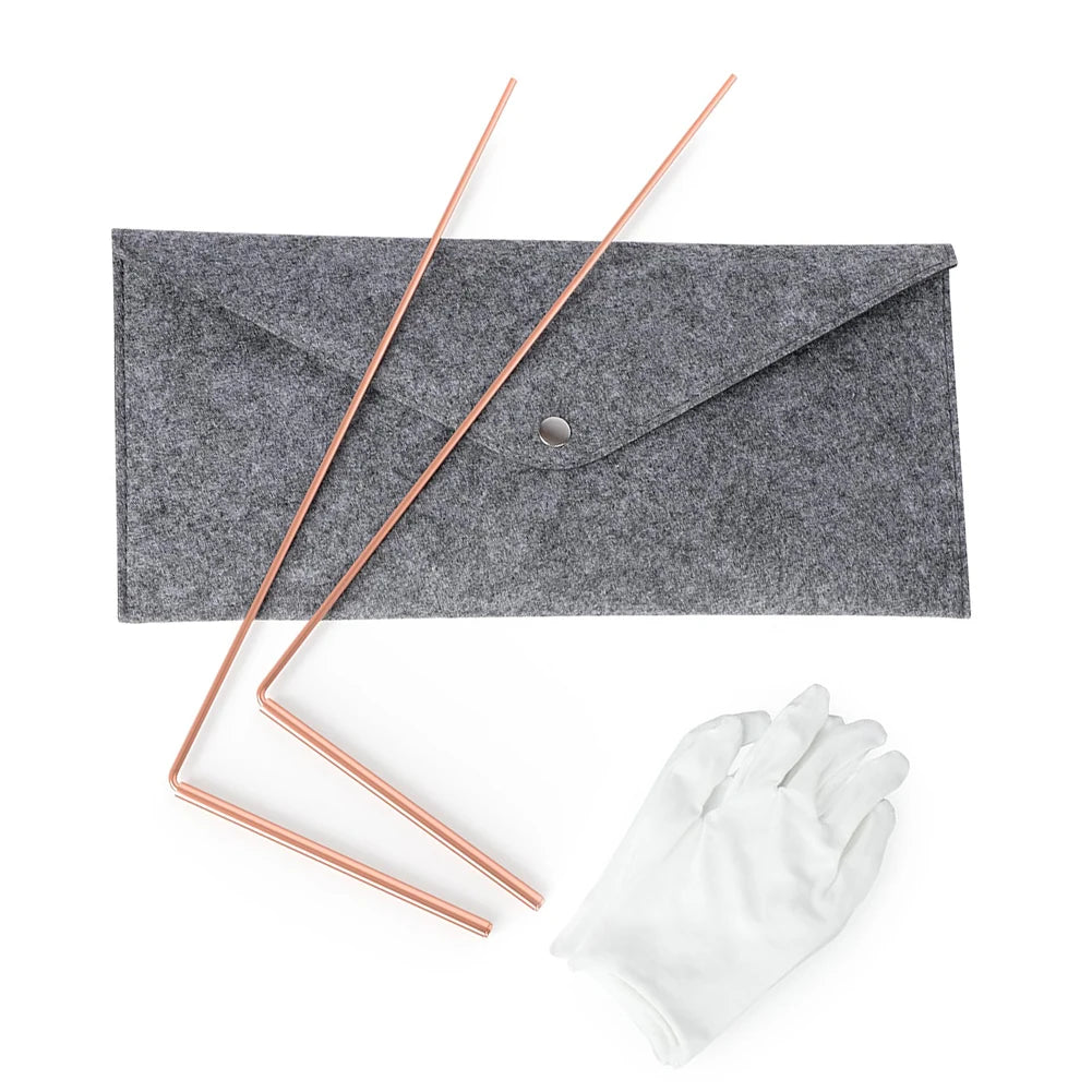 Une enveloppe grise avec deux tiges de divination en cuivre et un gant blanc sur fond blanc.