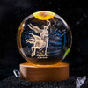 A spherical crystal ball with a golden top showing a silhouette of a leaping figure and the date 11.22.12.