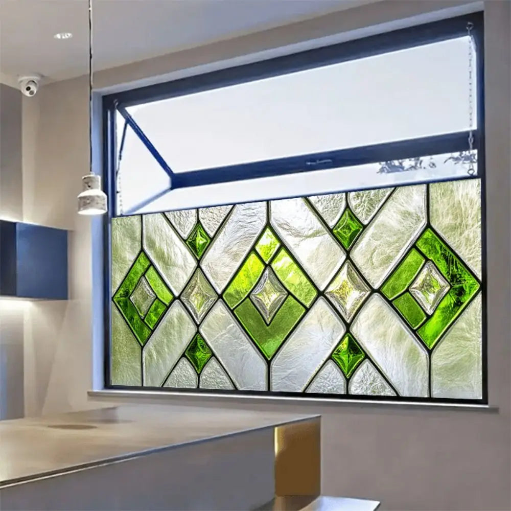 A close-up of a retro European green leaf privacy window film installed in a modern window frame.