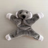 A gray plush elephant toy with white accents, used as a fridge magnet.