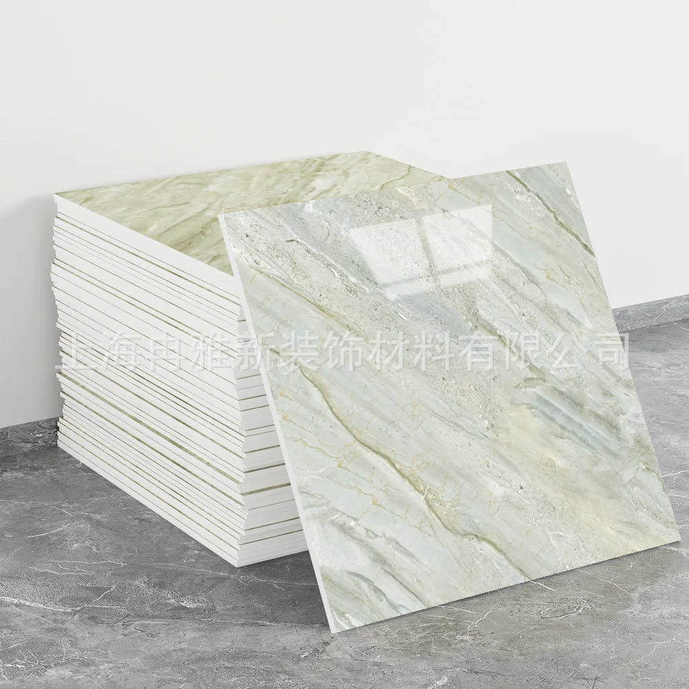 A rectangular slab of light beige and white marble-patterned faux stone tile displayed on a gray floor.