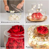 Clear acrylic cake stand display box with LED lights featuring red roses and white flowers.