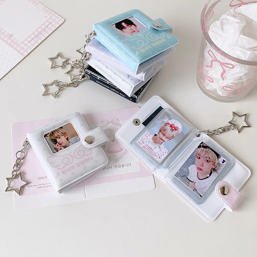 A collection of mini snap button photo albums and cards with silver chains arranged on a white surface.