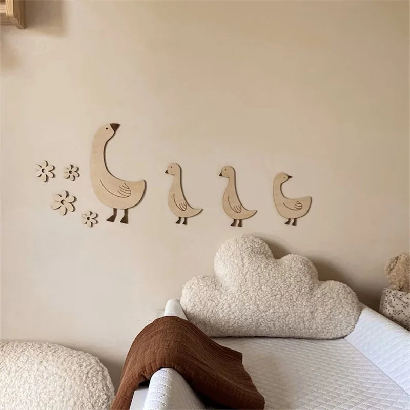 Handcrafted wooden goose wall art with floral accents displayed on a light-colored wall.