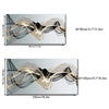 Abstract wall art featuring flowing golden ribbon lines on a dark gray background