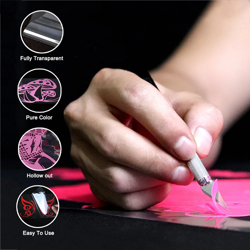 A hand is using a decorative kitchen wall sticker set to create a design on pink paper.