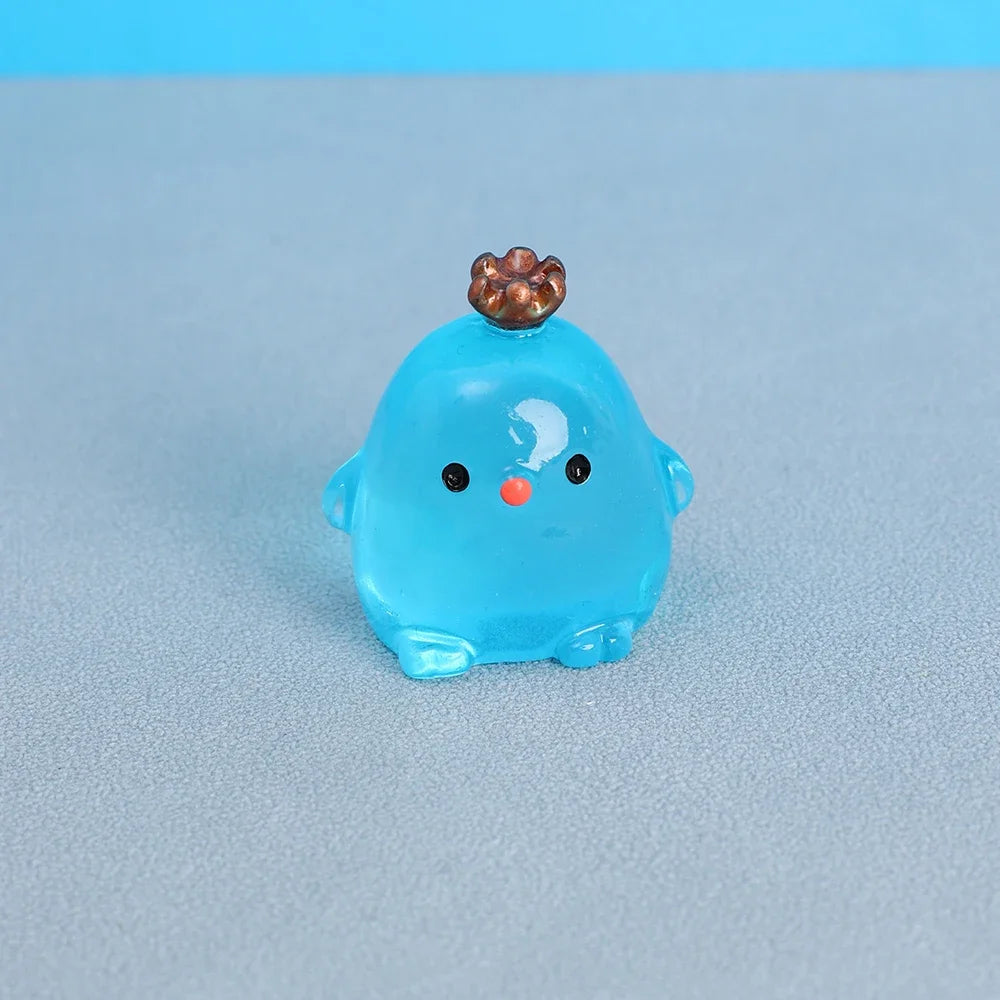 A small, translucent blue resin chicken ornament with a bronze-colored comb and a small orange eye.