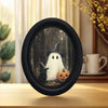 Vintage wall art featuring a white ghost and a black cat inside a round black frame.