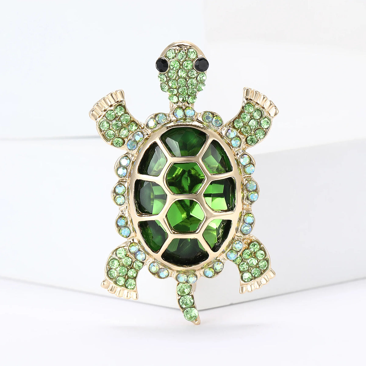 A vintage marine life brooch pin set featuring a gold-toned starfish with green and clear stones.