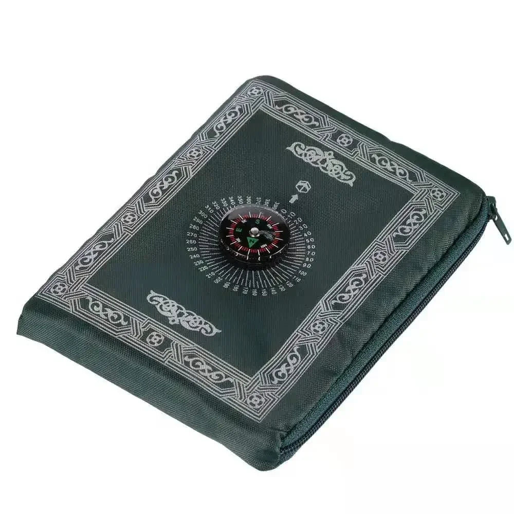 A dark green portable travel prayer mat featuring an engraved compass design.