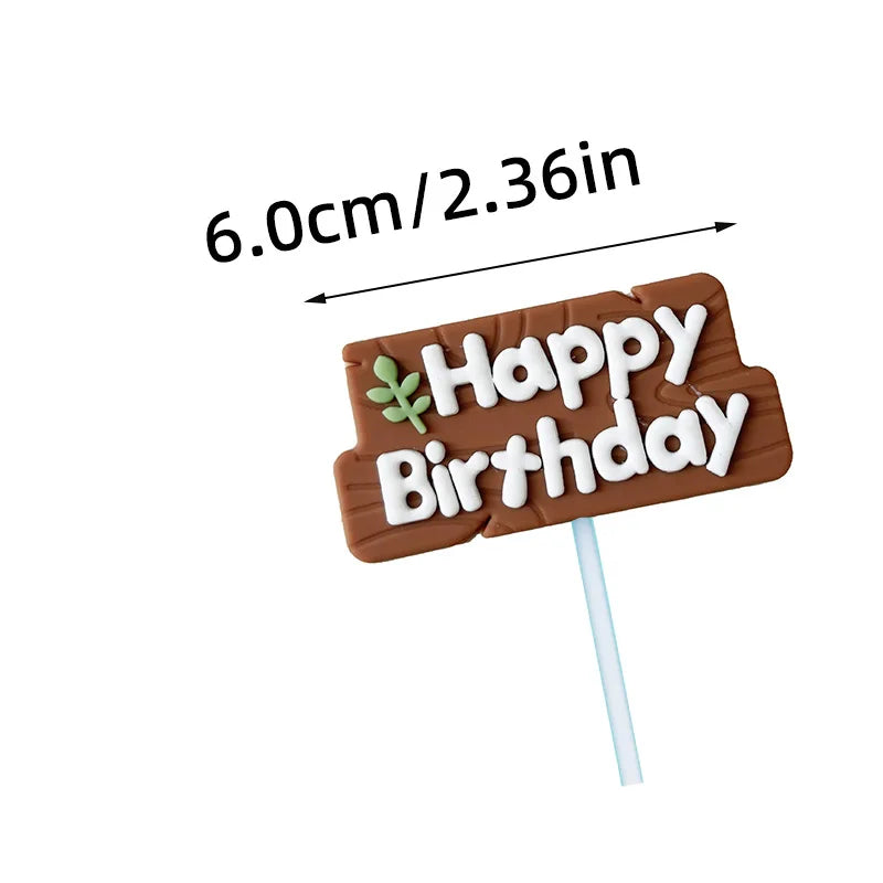 A brown gingerbread stick with white icing spelling out Happy Birthday and a leaf design.