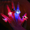 A hand holds several glowing Halloween-themed light-up rings, including a witch hat and a ghost face.