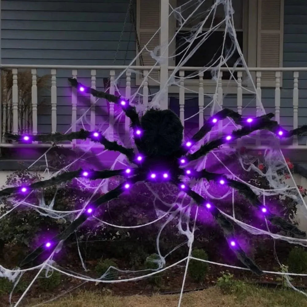 A large, black LED light-up furry spider decoration with purple glow is displayed on a porch railing.