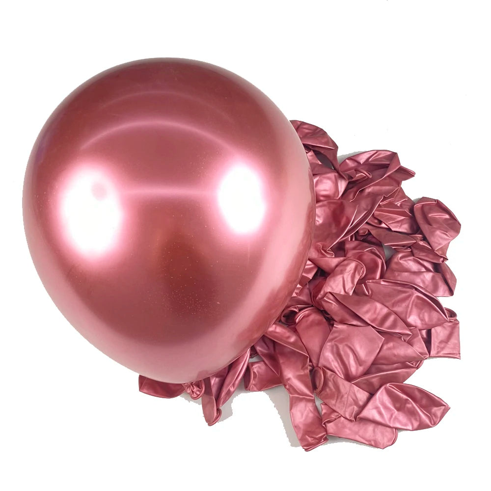 A single glossy rose gold latex balloon next to crumpled rose gold foil balloons.