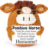 A handmade crochet horse doll with a positive message card.