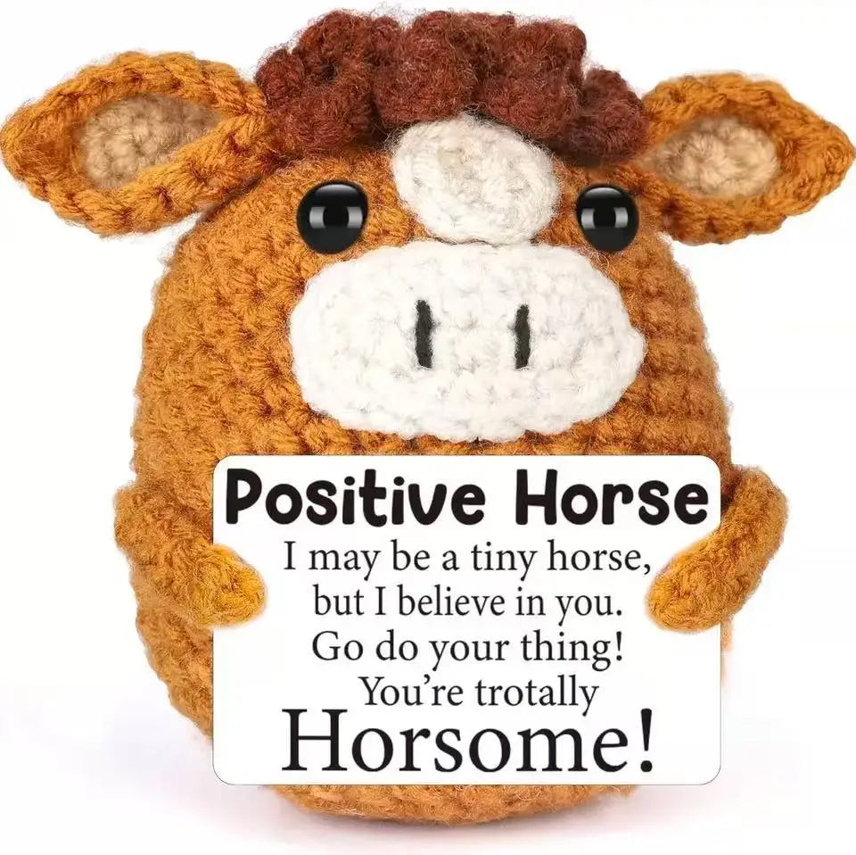 A handmade crochet horse doll with a positive message card.