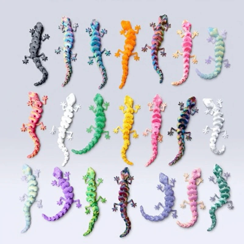 A collection of 3D printed articulated gecko desk toys in various bright and pastel colors.