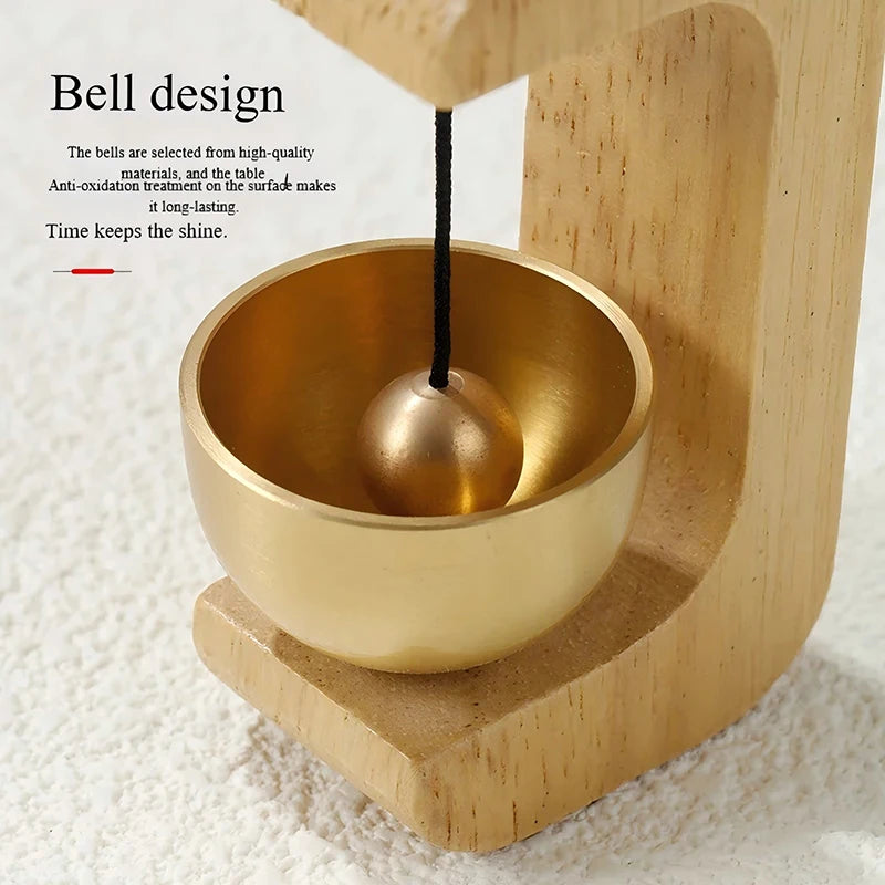 A golden bell is suspended from a black cord inside a wooden bowl, demonstrating the design of a magnetic wooden wind chime d