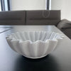 A white lotus leaf resin decorative bowl is displayed on a dark table.