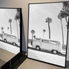 Black and white landscape poster featuring a white van driving past palm trees on a road.