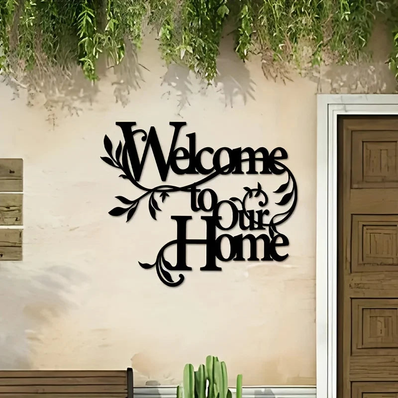 A black metal script sign welcoming visitors to a home mounted on an exterior wall.