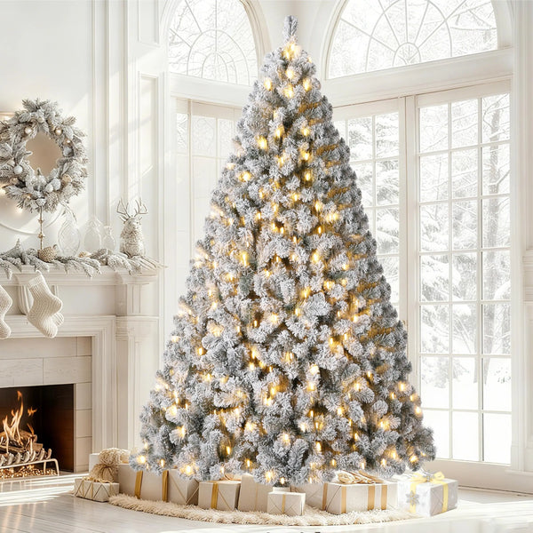 A flocked artificial Christmas tree decorated with warm white LED lights standing in a bright room.