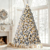 A flocked artificial Christmas tree decorated with warm white LED lights standing in a bright room.