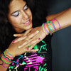 A woman wearing a set of glow-in-the-dark silicone bracelets on her wrist.