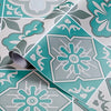 A close-up of a patterned wall sticker featuring teal and gray floral designs on a tile.