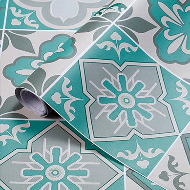 A close-up of a patterned wall sticker featuring teal and gray floral designs on a tile.