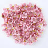 A pile of pink silk artificial flower heads used for weddings, crafts, and home decor.