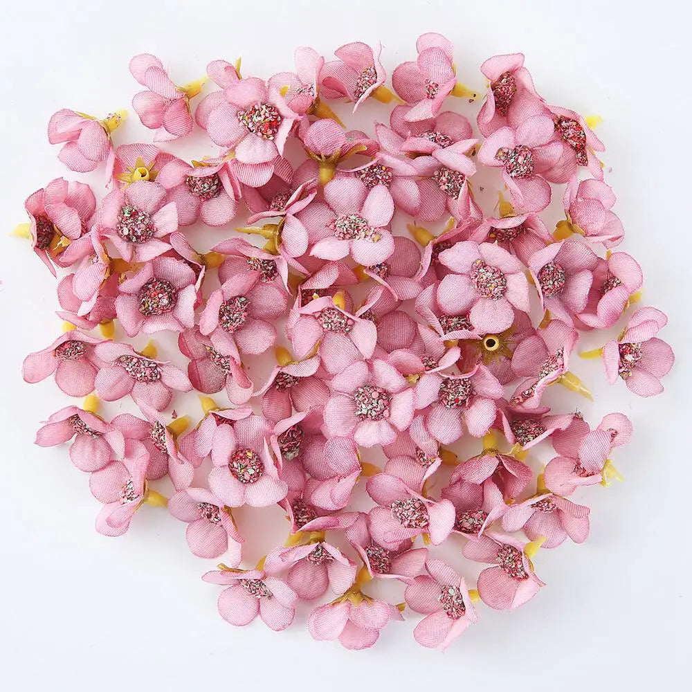 A pile of pink silk artificial flower heads used for weddings, crafts, and home decor.