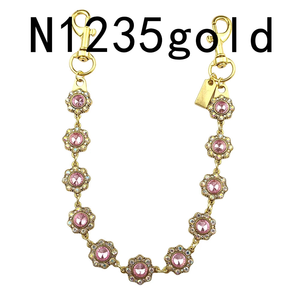 Gold necklace with pink and clear rhinestones and a pendant on a gold chain.