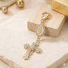 Gold pearl rhinestone cross keychain charm with a round medallion on a light background