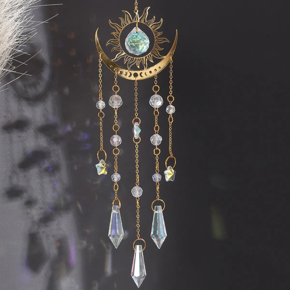 A gold flame moon crystal sun catcher featuring a crescent moon and hanging crystal beads.