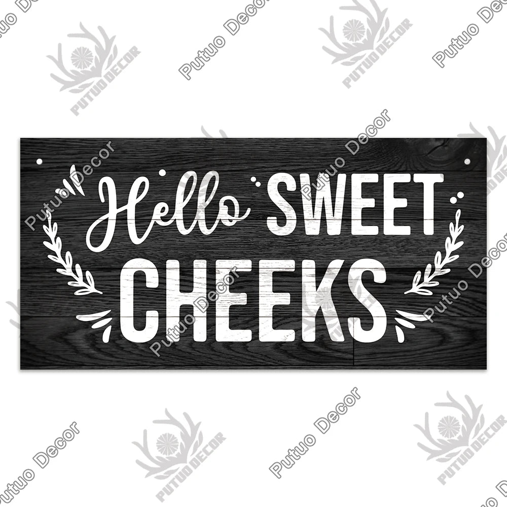 Rustic wooden sign with white script text that reads Hello Sweet Cheeks