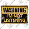 A vintage yellow metal sign with black text that reads WARNING I'M NOT LISTENING.