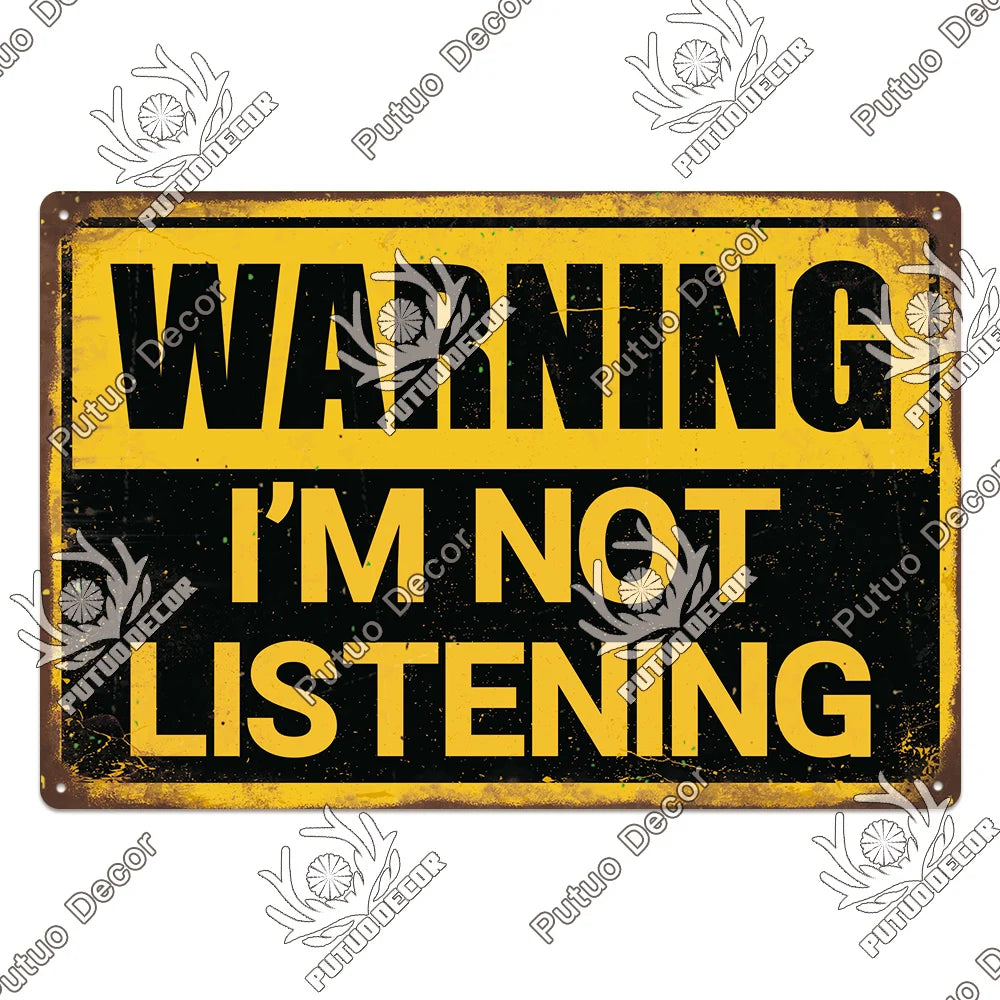 A vintage yellow metal sign with black text that reads WARNING I'M NOT LISTENING.