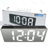 A rectangular LED clock display showing 12:04 on a white box.